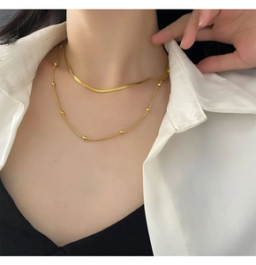 Close-up of double layer gold snake chain necklace worn on model neck for styling