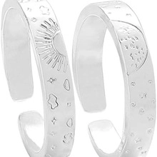 Detailed view of silver open rings with sun moon and star engraved patterns
