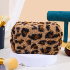 Detailed texture of brown leopard print plush makeup bag on a professional display stand