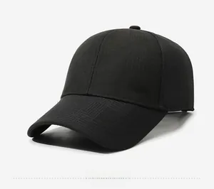 Detail of black baseball cap showing textured fabric and silver metallic logo on side