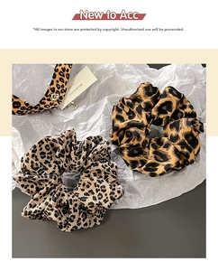 Detailed view of leopard print hair scrunchies in light brown and deep caramel tones