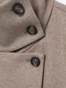 Detail of light brown wool jacket fabric texture and three dark round buttons close-up