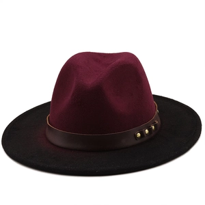 Close-up of felt fedora with burgundy crown, black brim and leather belt with gold studs