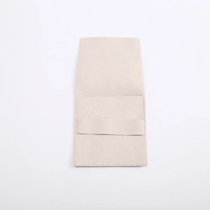 Close-up of beige microfiber jewelry pouch with flap cover and soft texture