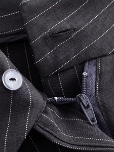 Gros plan détaillé du pantalon large à rayures avec bouton en résine et fermeture éclair