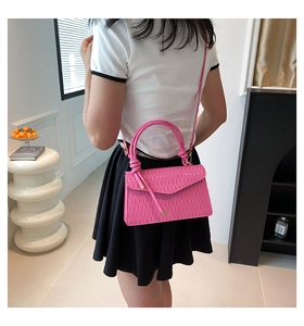 Detailed back view of pink pleated handbag with slim shoulder strap worn by a model