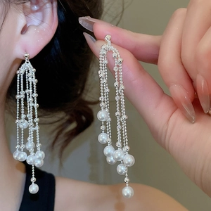 Detail of silver drop earrings featuring multiple pearl tassels and zircon accents