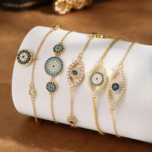 Golden evil eye charm bracelet set with blue zircon crystals for bohemian luxury style