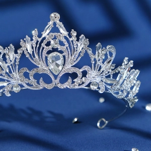 Luxurious silver crystal bridal crown with rhinestones on a navy blue silk background