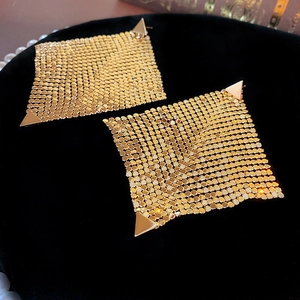 Detailed view of golden square mesh earrings featuring a unique woven metal fabric texture