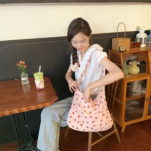 Gros plan détaillé du sac cabas en velours côtelé rose avec motif brodé de fraises douces