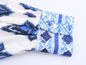 Vista macro detallada del puño con estampado azul y blanco y un botón blanco fino