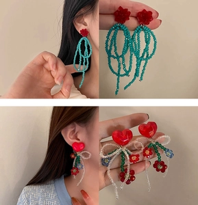 Detail of flower pearl tassel earrings with colorful beads and heart stud on model
