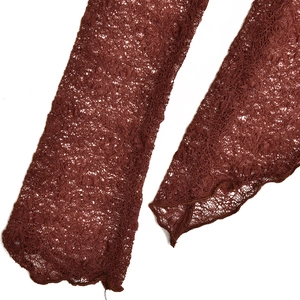 Close-up of reddish-brown lace sleeves with floral mesh texture and wavy scalloped edges