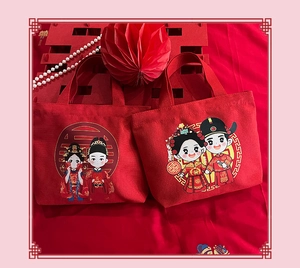 Detail of red wedding canvas tote bags with cartoon bride and groom illustration