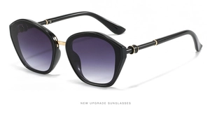 Detail of oversized polygon sunglasses with purple gradient lenses and gold metal bridge