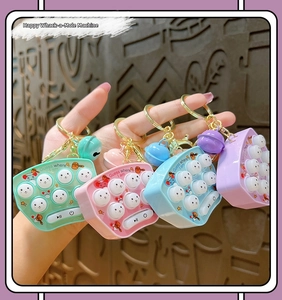Close-up of four colorful mini whack-a-mole game keychains with cute silicone buttons