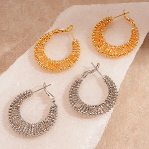 Minimalist hollow geometric gold and silver hoop earrings on a textured stone base