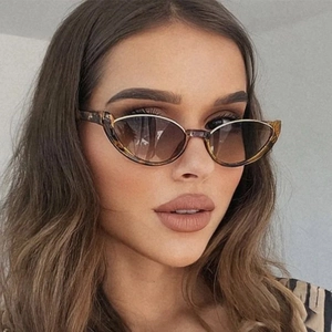 Close-up of tortoise shell cat-eye sunglasses with gradient brown lenses on a female model