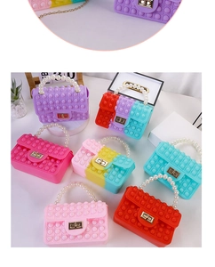 Various colorful silicone pop-it bags for kids with pearl handles and gold clasps