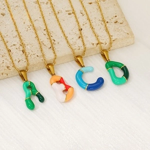 Detail showing A to D letter pendants with colorful enamel on thin golden chain