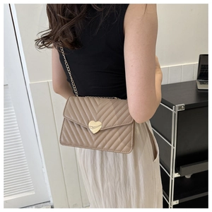 Dettaglio borsa a tracolla beige trapuntata in PU con chiusura a cuore dorata e catena