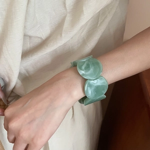 Detailed view of light green marble acrylic bracelet with large round resin pieces