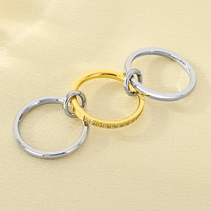 Macro shot of interlocking silver and gold rings with sparkling diamond accents