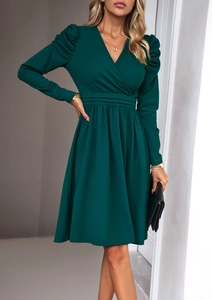 Detail of dark green V-neck dress featuring elegant waist pleats and A-line silhouette