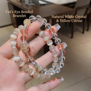 Bracelet en perles de cristal naturel, quartz rutilé jaune et œil de chat tenu à la main