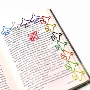 Colorful airplane shaped metal paperclips organized on an open book page