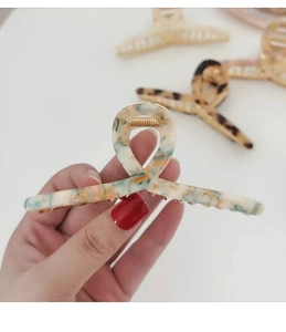 Detailed close-up of a large cream marble acetate claw clip with gold metal spring