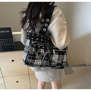 Detail of checkered tote bag featuring metal rivets, silver chains and street punk style