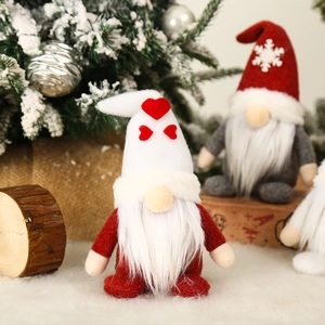 Plush Christmas gnome doll with white heart hat and long beard on festive background