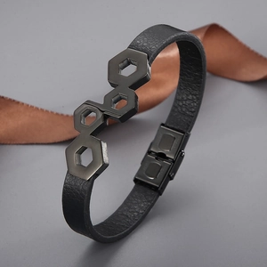 Detail of black leather braided bracelet with dark hexagonal stainless steel ornament