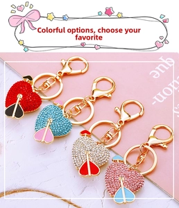 Close-up of four colorful heart-shaped keychains with rhinestones and arrow design