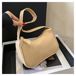 Detail of apricot underarm bag with smooth PU leather texture and curved silhouette