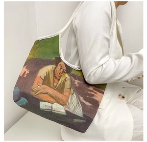 Detail of oil painting canvas tote bag featuring classical reading scene on a white suit model