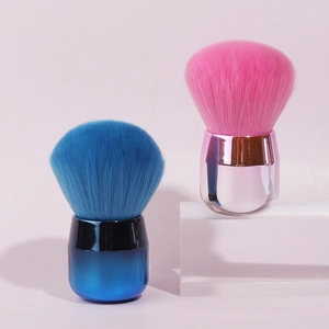 Detail of blue and pink mushroom-head powder brushes with metallic handles and dense bristles