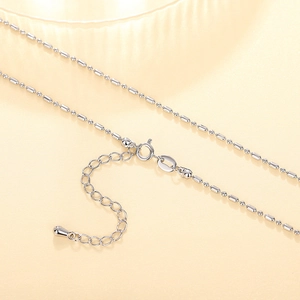Macro detail of silver bead chain necklace with lobster clasp and adjustable extension