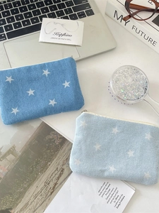 Denim star print coin purse and lipstick pouch set shown in a daily lifestyle flatlay