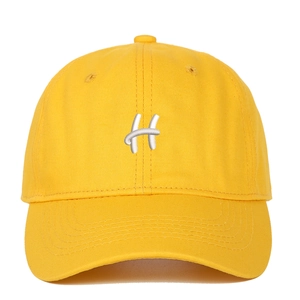 Close-up of premium yellow cotton baseball cap with thick white 3D letter H embroidery
