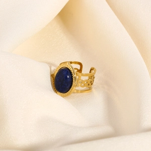 Macro shot of gold vintage open ring featuring a deep blue oval stone and woven texture