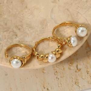 Three-piece gold stainless steel ring set featuring lustrous shell pearls on marble