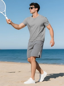 Men's breathable quick-dry fitness set in light grey t-shirt and dark grey shorts on beach