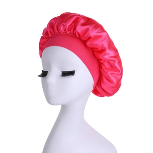 Detail view of high elasticity wide band satin bonnet in rose red on a model