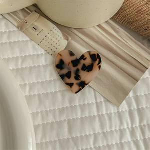 Detail of a brown leopard print heart hair clip with handmade France lettering