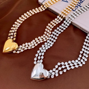 Detail of layered waist chain with sparkling rhinestones and large polished heart pendants