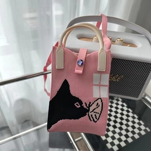 Détail du mini sac tricoté rose avec silhouette de chat et motif de fenêtre blanche