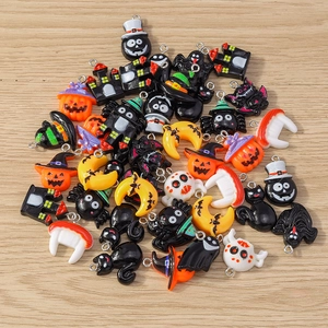 Mix of Halloween cartoon charms with pumpkin ghost and bat shapes on wooden table